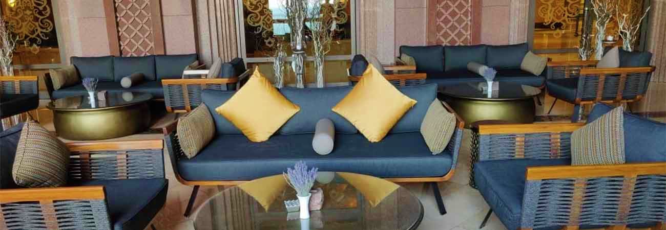Elegant lounge seating area with blue sofas, yellow accent pillows, and wooden frame furniture at Emirates Palace Abu Dhabi l
